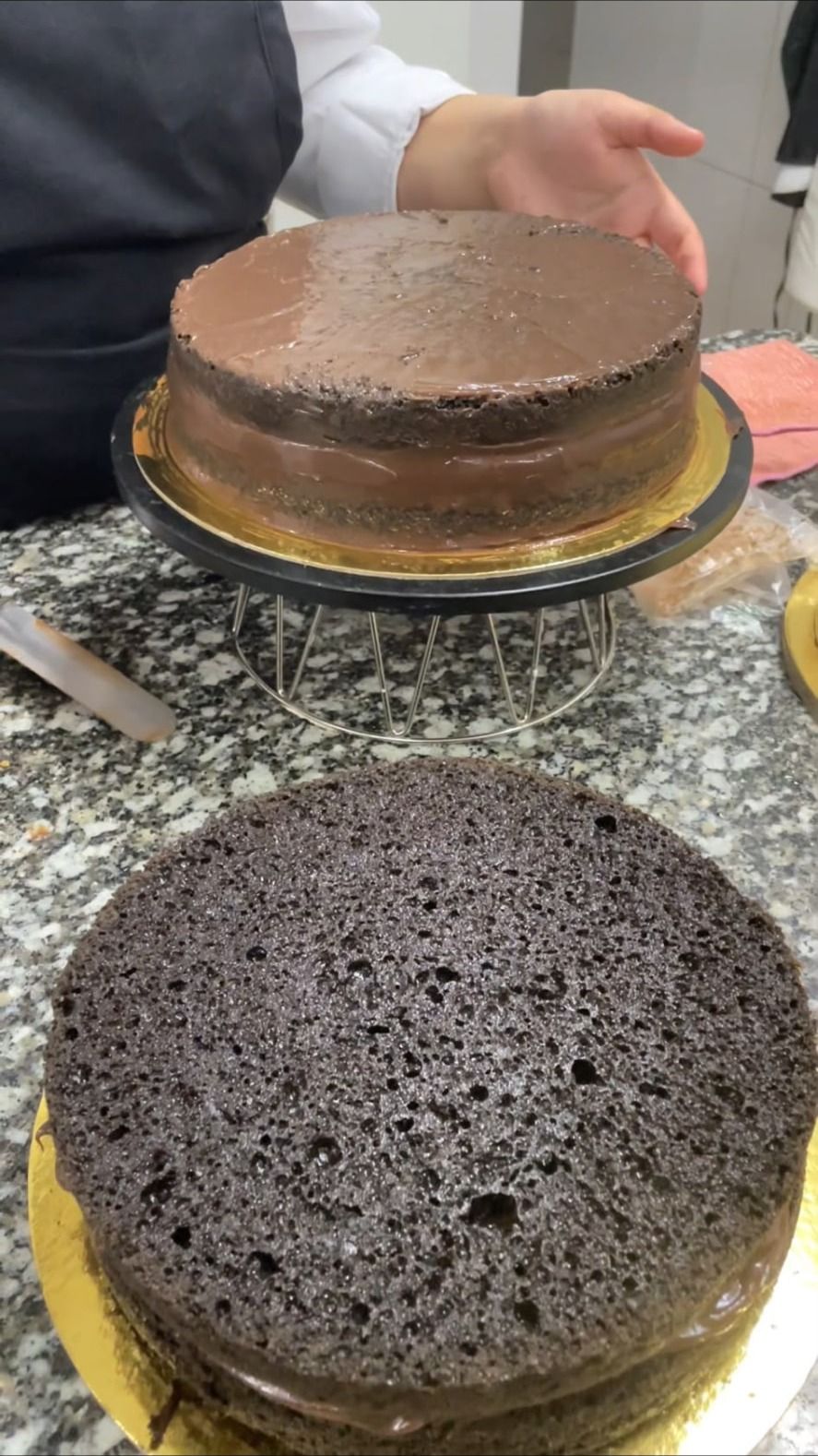 Camadas de bolo de chocolate alinhadas na bancada, prontas para montagem na fábrica de Gondomar